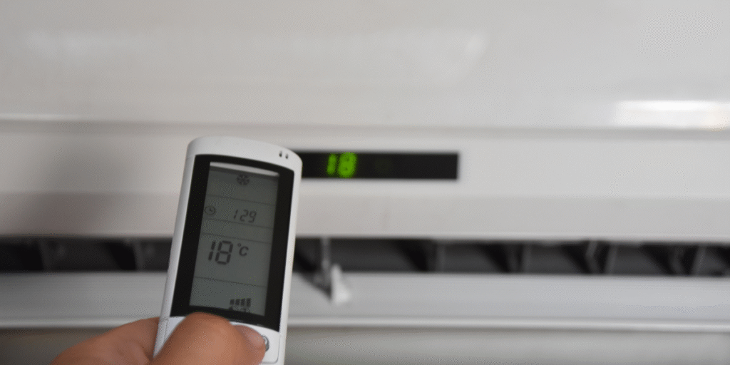 Close-up of an air conditioner remote set to 18°C, showing a thermostat change on its own while adjusting an air conditioning Gold Coast unit.