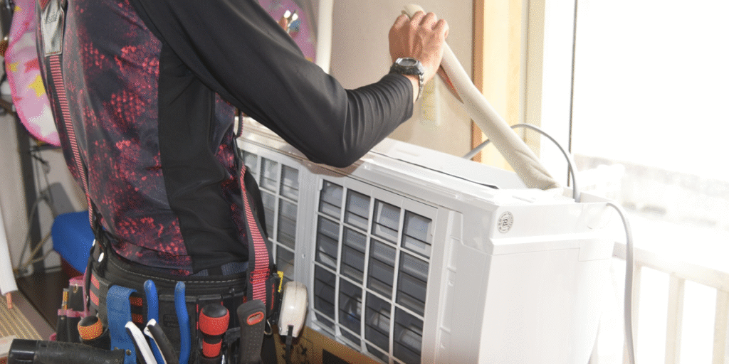 Residential air conditioning Gold Coast technician servicing an indoor unit, explaining why we don’t always connect gauges during preventative maintenance.