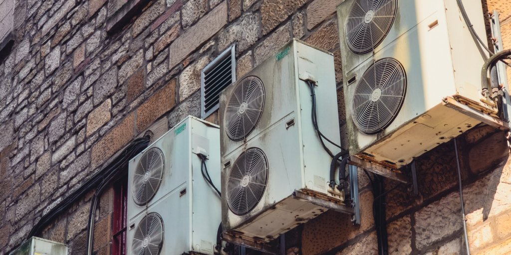 Outdoor air conditioning units exposed to moisture and corrosion, highlighting why preventative maintenance helps prevent rust for air conditioning Gold Coast systems.
