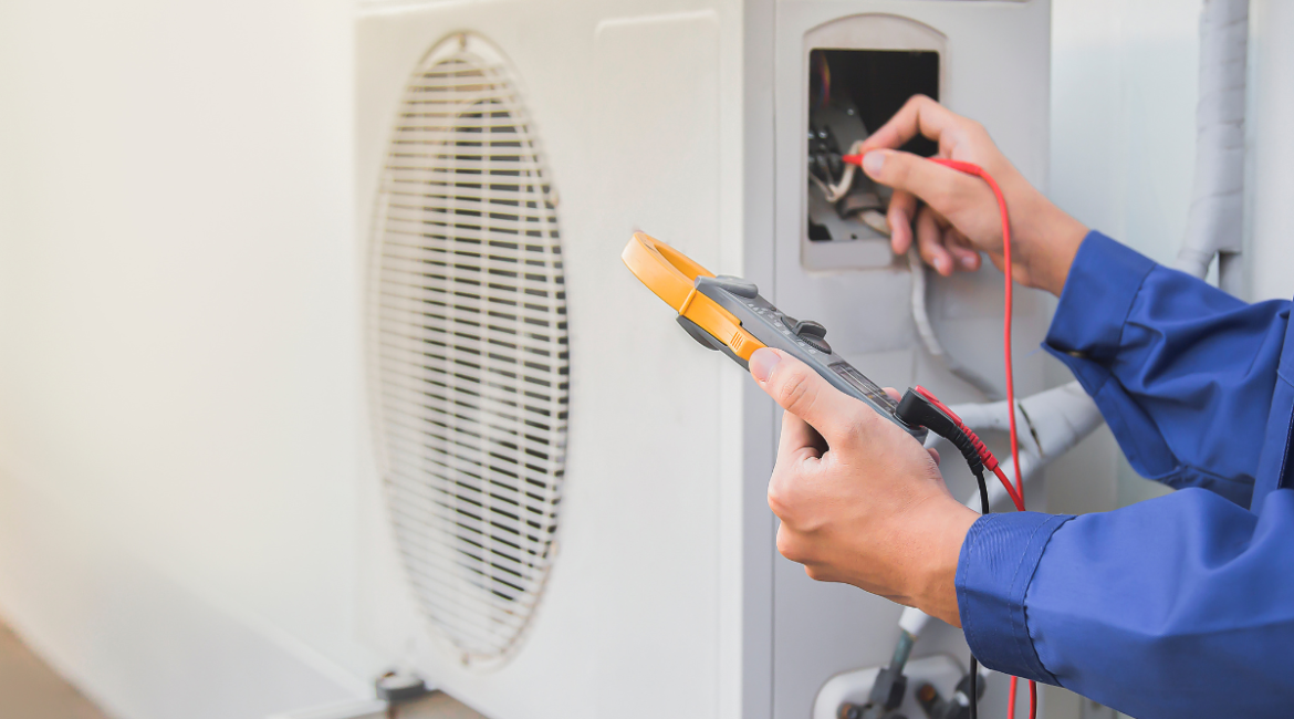 Technician inspecting an outdoor AC unit for refrigerant leaks to prevent refrigerant poisoning in commercial air conditioning Gold Coast systems.