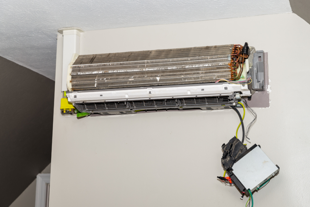 Black dust buildup inside an air conditioner unit, showing dirty coils that can cause black dust coming out of your air conditioner vent in residential air conditioning Gold Coast homes.