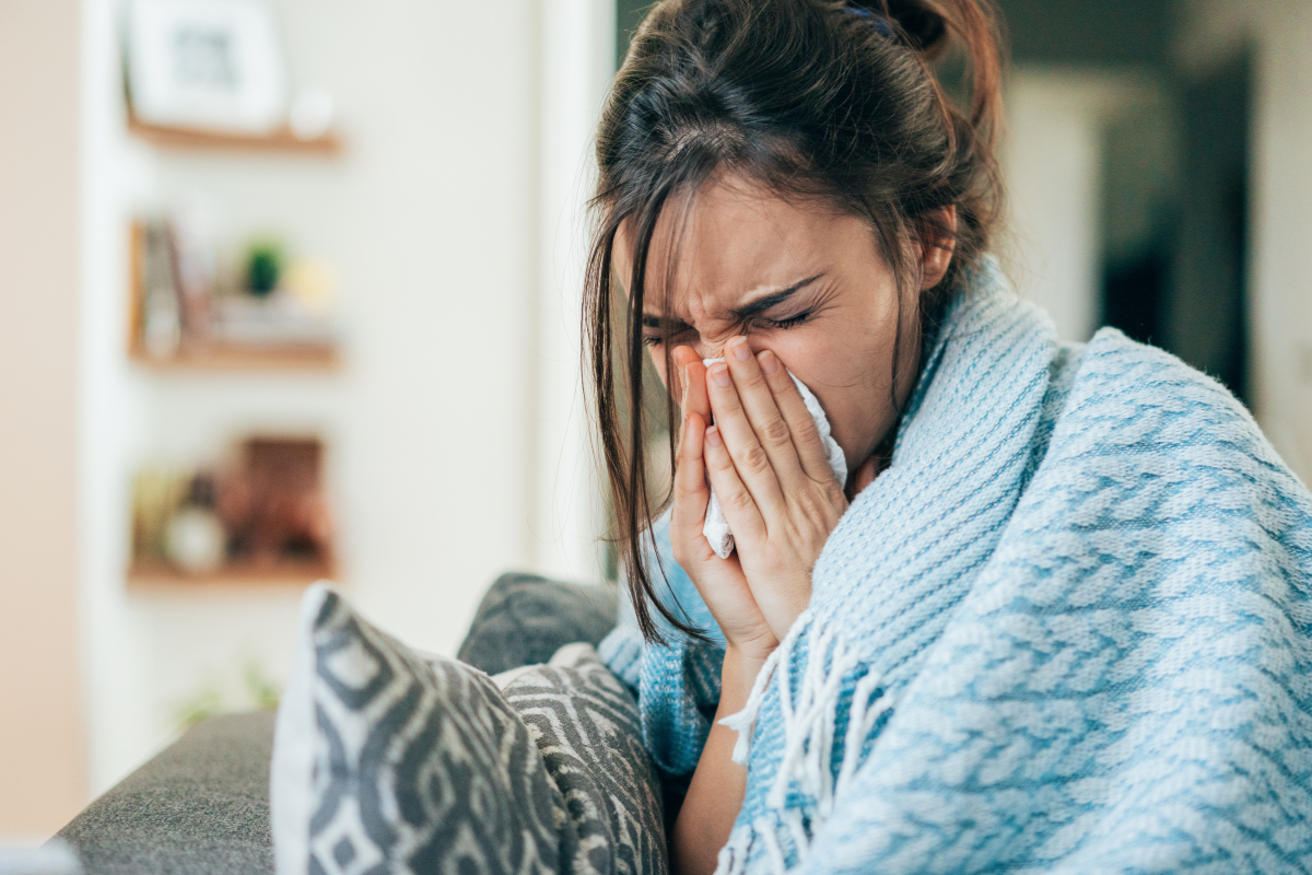 The woman wearing a blue blanket is having sick building syndrome. This is a syndrome that the owner of residential and commercial air conditioning has