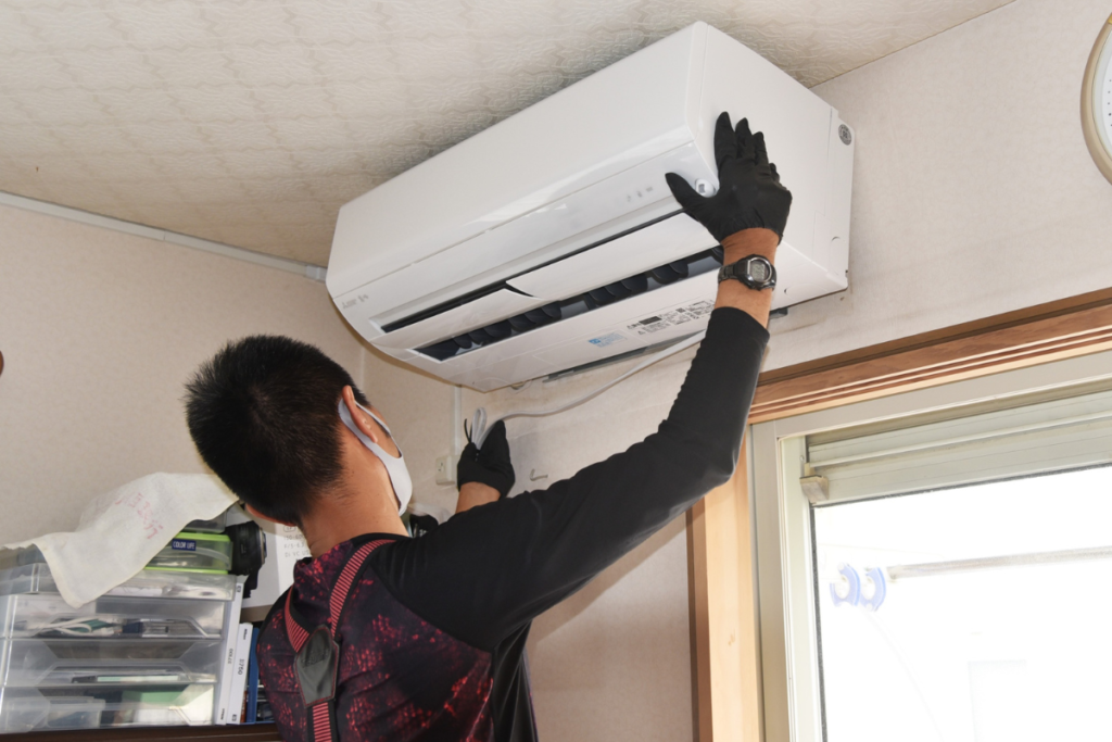 Technician inspecting an air conditioner that starts normally then stops, diagnosing turn on and off repeatedly problems in residential air conditioning Gold Coast