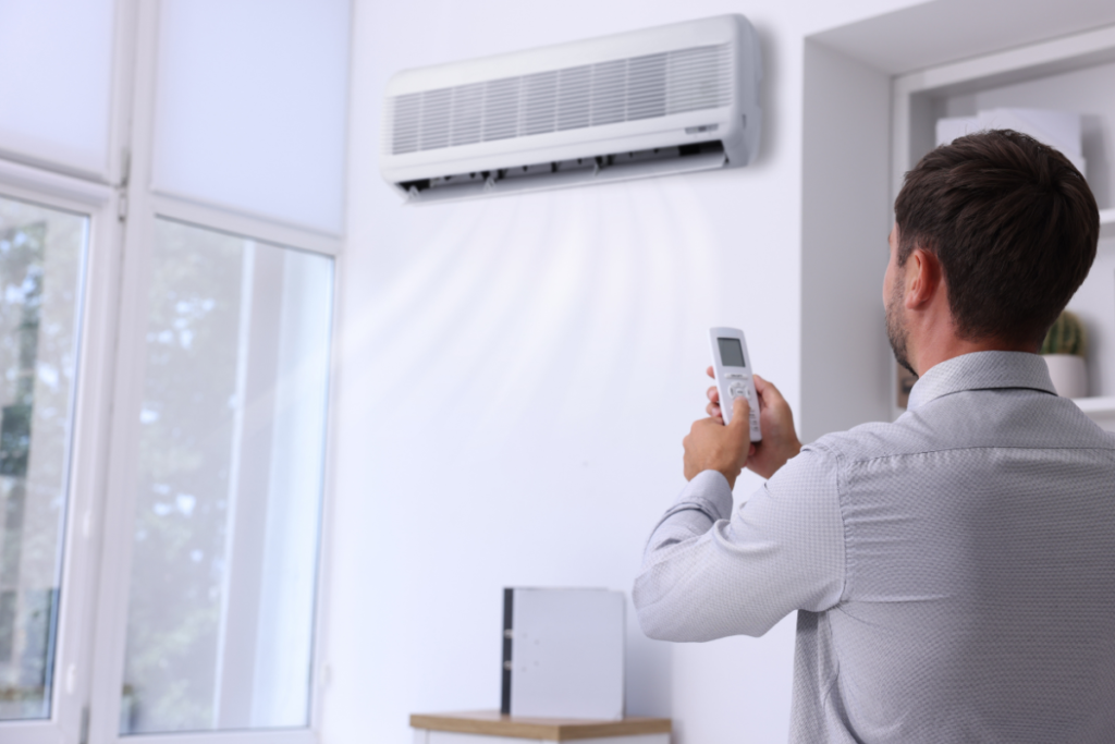 A homeowner adjusting temperature using air conditioner right way in heatwave, setting the correct mode during 40°C conditions in air conditioning Gold Coast homes.