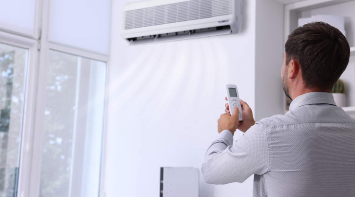 A homeowner adjusting temperature using air conditioner right way in heatwave, setting the correct mode during 40°C conditions in air conditioning Gold Coast homes.