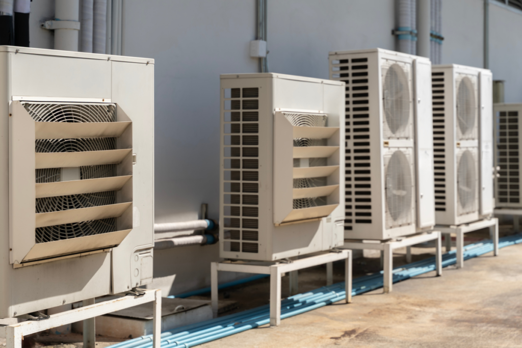 Multiple outdoor air conditioning units working under extreme heat, showing what to consider before replacing systems with air conditioning Gold Coast experts.