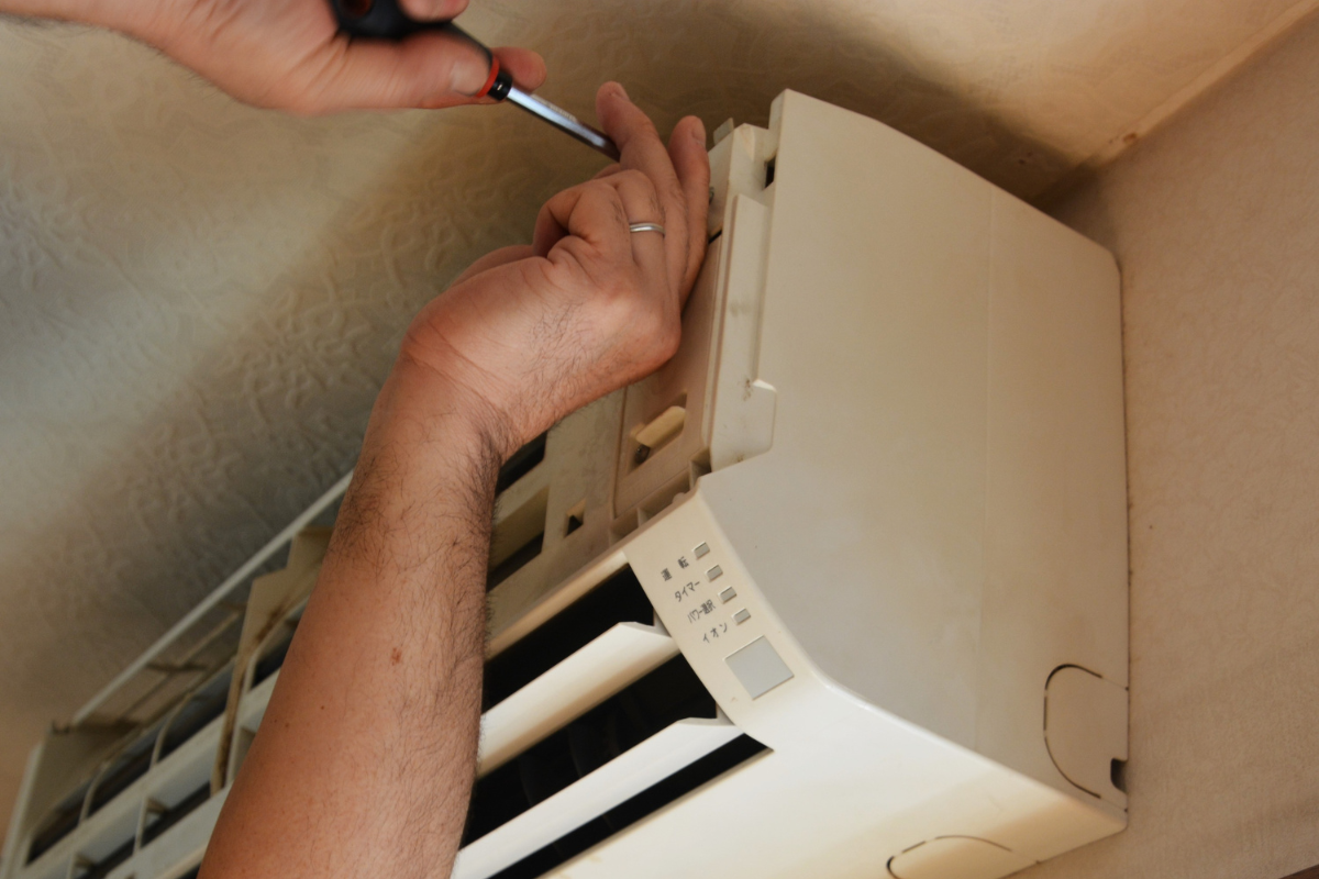 Professional checking internal components before recommending to replace your air conditioner, residential air conditioning Gold Coast upgrade project.
