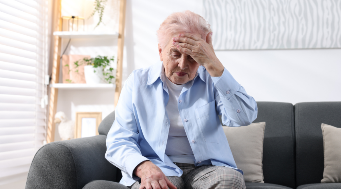 Elderly woman uncomfortable due to stuffier in early autumn conditions, questioning why is my house so hot even when it's cold outside in air conditioning Gold Coast residence.