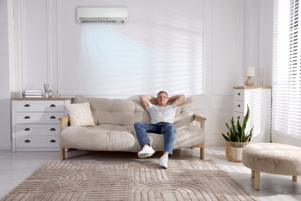 Man relaxing on sofa under wall unit.