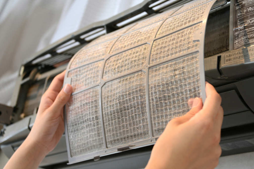 Turning off air conditioner process by removing and cleaning dirty filter before fall maintenance, air conditioner Gold Coast service preparation.