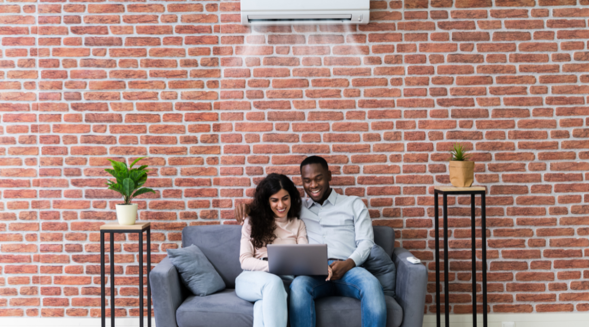 Couple relaxing under split system in modern living room, showcasing LG vs Panasonic comparison among the Best air conditioners in Australia for residential and commercial air conditioning Gold Coast needs.