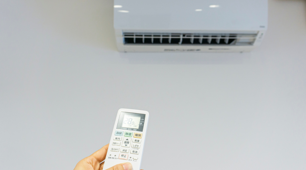 Person adjusting air conditioner to manage humidity indoors – Is 70% humidity very high and is humidity bad for an air conditioner? Air conditioning Gold Coast comfort control.