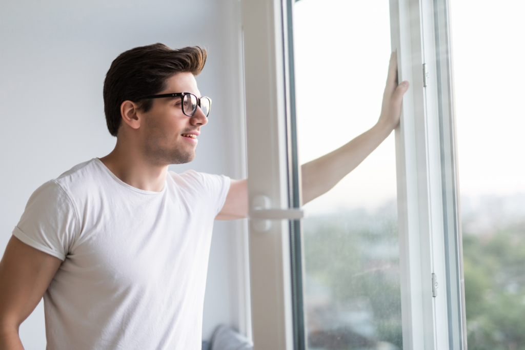Man opening the window for fresh air circulation, does opening the window decrease humidity in air conditioning Gold Coast
