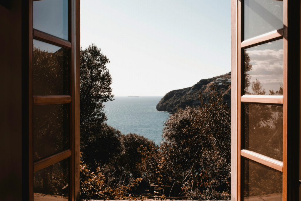 Ocean view through open window showing natural ventilation, opening the window decrease humidity in residential air conditioning Gold Coast
