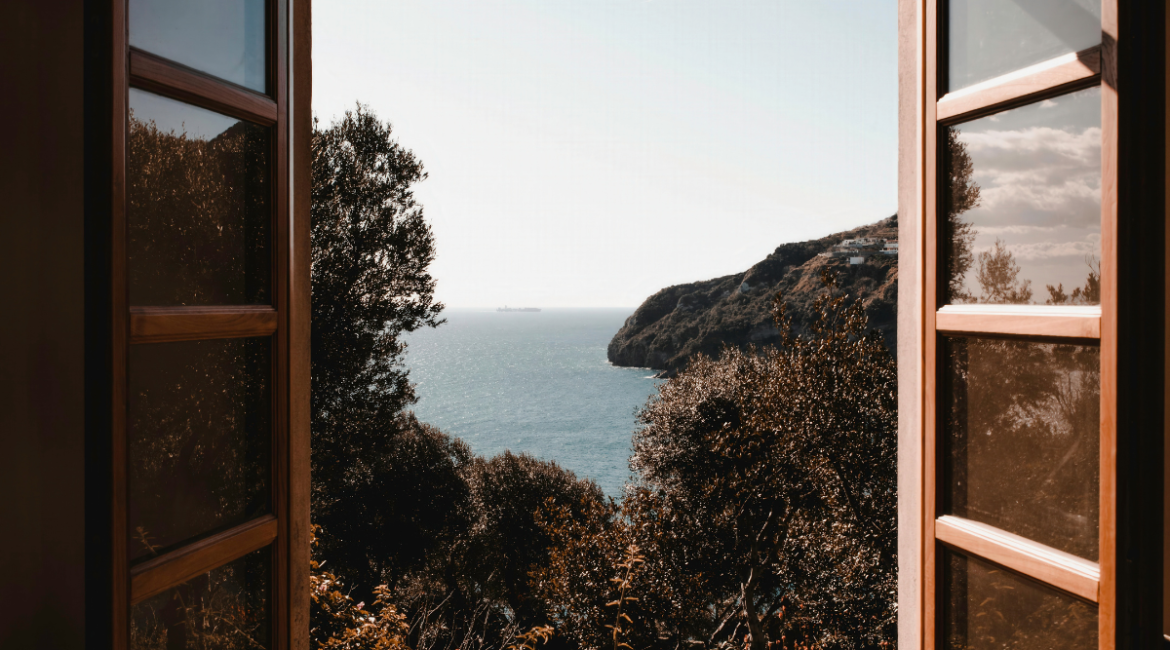 Ocean view through open window showing natural ventilation, opening the window decrease humidity in residential air conditioning Gold Coast