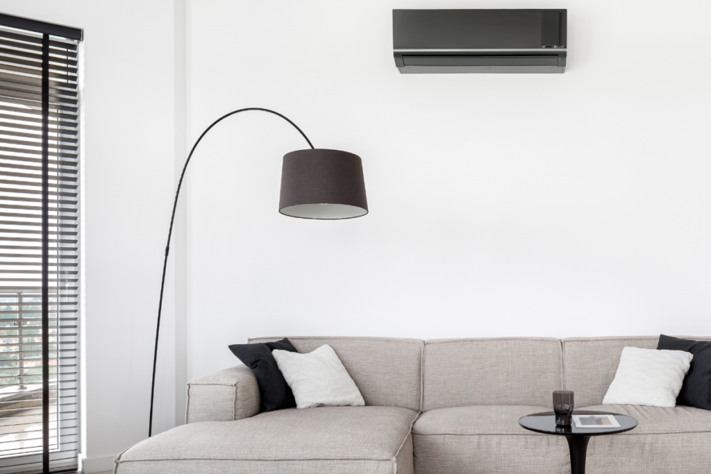 Minimalist living room interior with wall split system demonstrating how to tell if your AC is working harder during season change, a common issue in air conditioning Gold Coast properties.