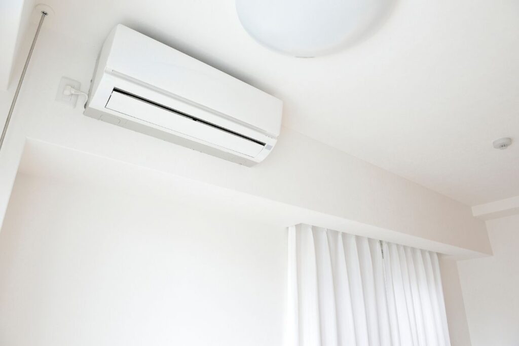 A clean white wall-mounted air conditioner blowing cool air, prompting homeowners to ask does air conditioning make the air too dry during air conditioning Gold Coast usage.