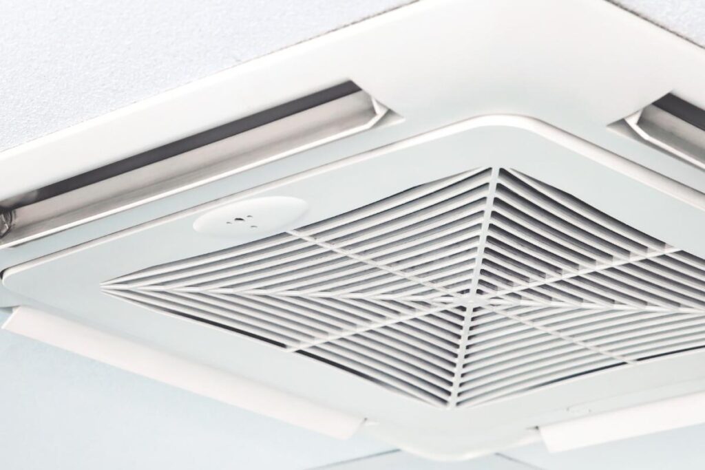 Close-up of a ceiling cassette air conditioning unit, explaining how commercial air conditioning Gold Coast systems control humidity and if air conditioning makes the air too dry.