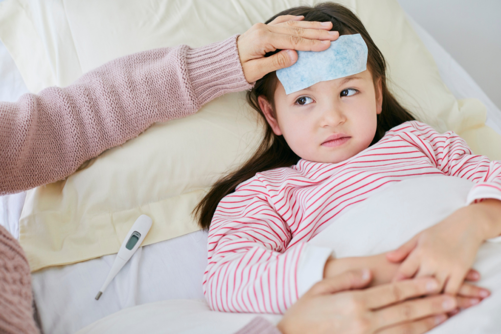 A mother comforting her daughter who has a fever in bed, answering the common question: can children sleep aircon when have a fever safely with residential air conditioning Gold Coast systems?