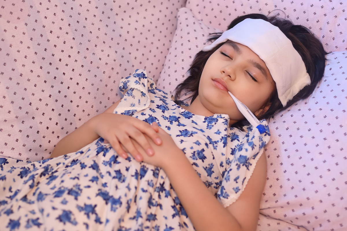 A child with a fever sleeping peacefully with a cold compress on her forehead, resting in a comfortable room maintained by expert air conditioning Gold Coast technicians.