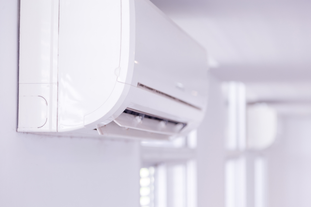 A long perspective view of a row of multiple identical white wall-mounted air conditioners in a brightly lit commercial space. This demonstrates the scale of commercial air conditioning gold coast installations, which can make air dry very quickly if humidity isn't monitored.