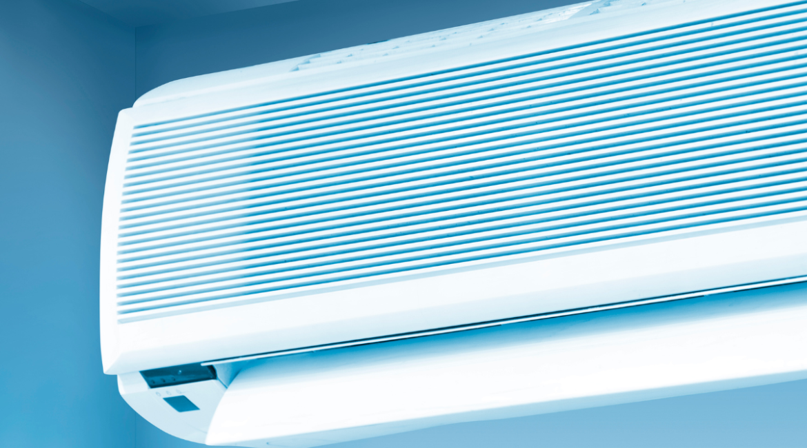 Close-up of a sleek, modern white indoor AC unit, angled against a soft blue wall. Discussing how residential and commercial air conditioning gold coast systems can make air dry, especially when not regularly maintained.