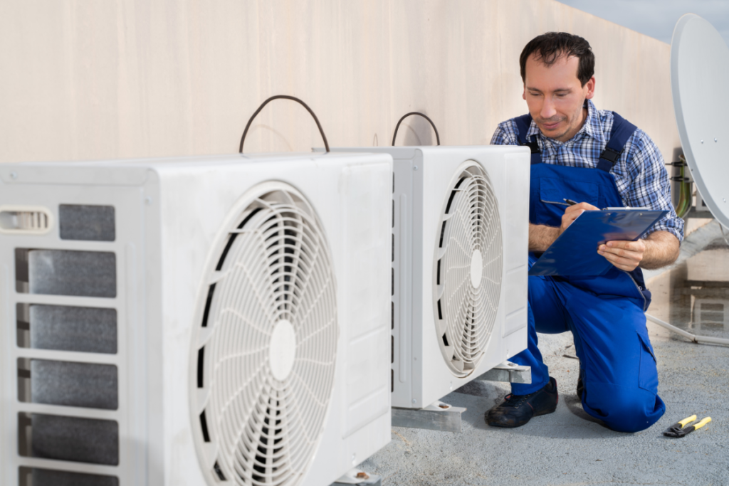 Technician inspecting outdoor commercial air conditioning units as part of a hotel HVAC maintenance checklist, supporting winter AC maintenance checklist procedures and reliable commercial air conditioning Gold Coast performance.