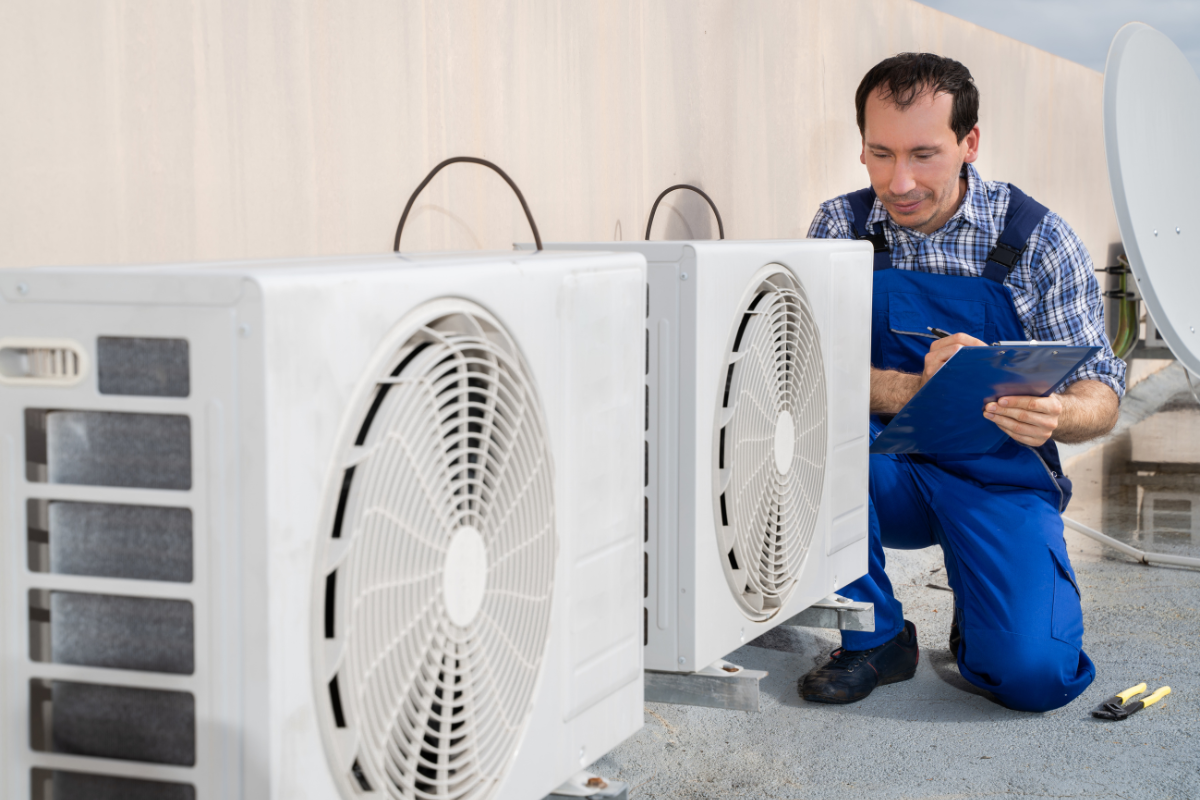 Technician inspecting outdoor commercial air conditioning units as part of a hotel HVAC maintenance checklist, supporting winter AC maintenance checklist procedures and reliable commercial air conditioning Gold Coast performance.