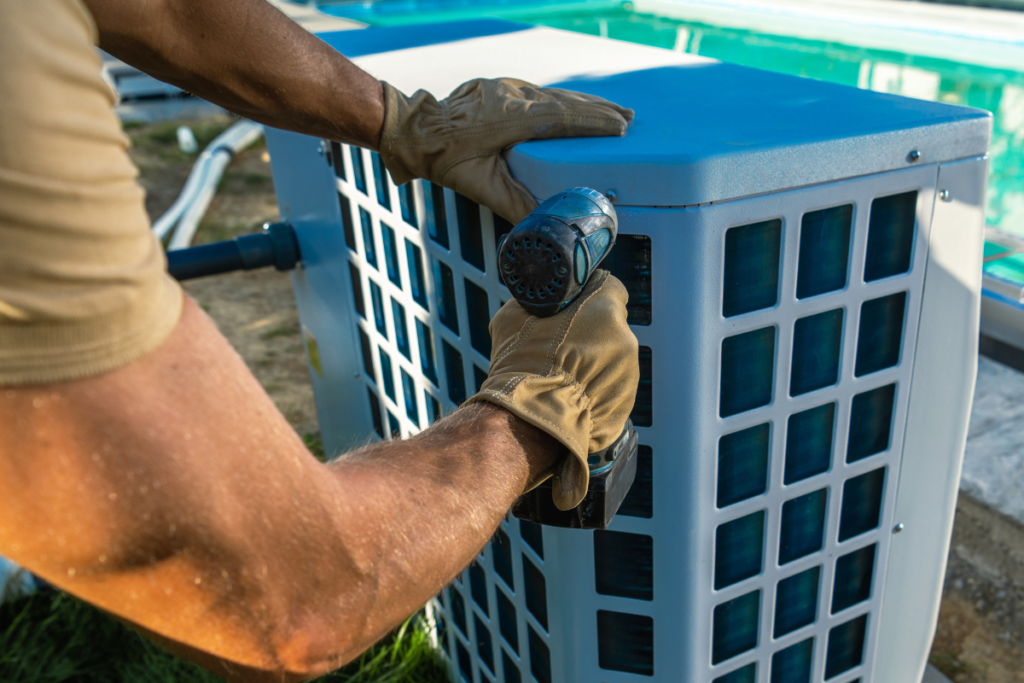 HVAC technician securing a commercial outdoor condenser unit during scheduled hotel HVAC maintenance, following a detailed commercial heating checklist and winter AC maintenance checklist for optimal system efficiency.