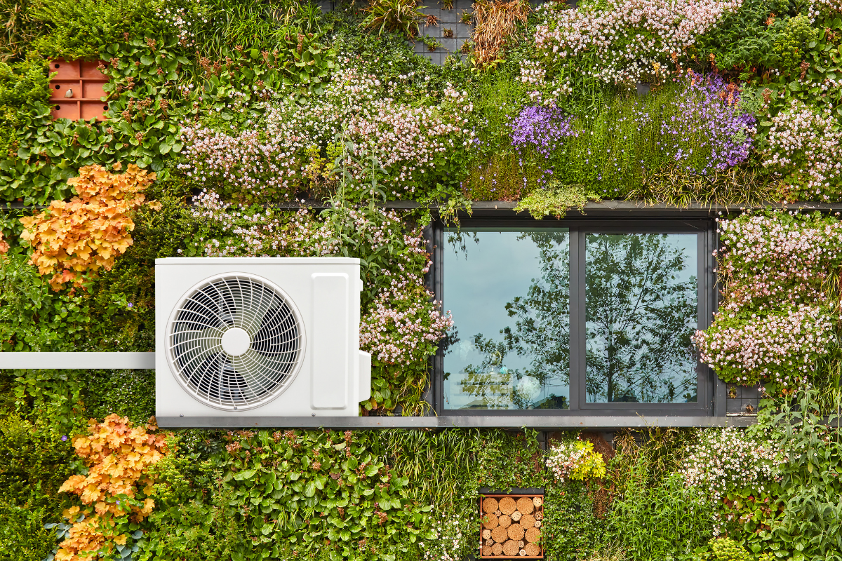 An outdoor compressor unit mounted on a lush vertical garden, perfectly illustrating sustainable cooling solutions and Panasonic ECO AI efficiency for commercial air conditioning Gold Coast.
