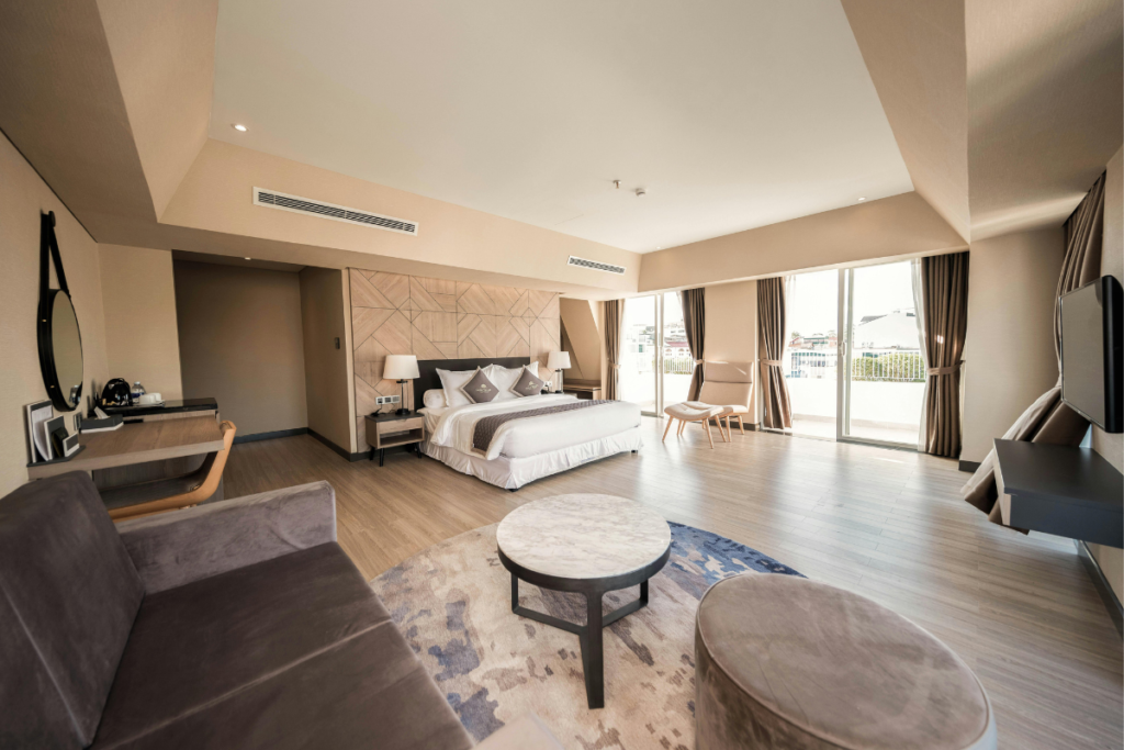 A luxury modern boutique hotel bedroom layout featuring a split system air conditioning gold coast unit mounted on the wall above the bed, where a hotel AC not heating problem requires professional hotel HVAC maintenance and commercial air conditioning gold coast solutions.