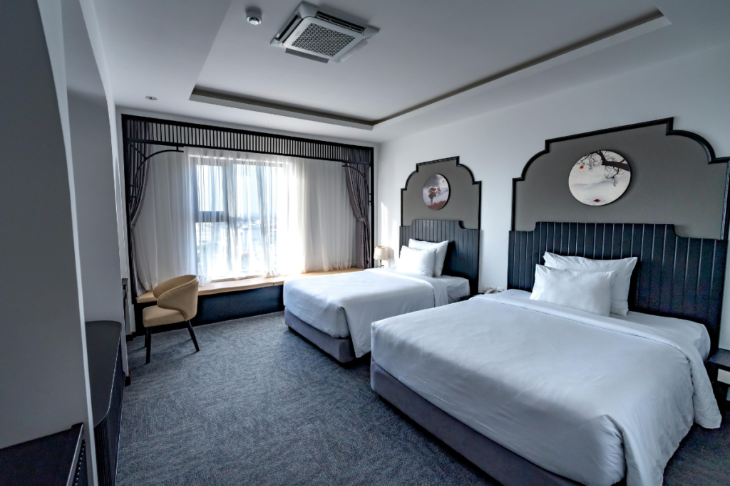An elegant empty resort suite bedroom with an indoor air conditioning gold coast wall unit, highlighting how a hotel AC not heating fault during cold months can be avoided with reliable winter AC maintenance Gold Coast plans and commercial air conditioning gold coast services.