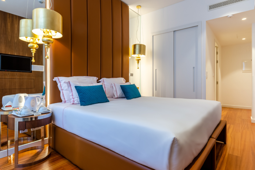 A clean and beautifully decorated accommodation room interior with a split system air conditioning gold coast unit above the bed, emphasizing the need for regular hotel HVAC maintenance and preventative winter AC maintenance Gold Coast to stop hotel AC not heating issues from affecting guest comfort.