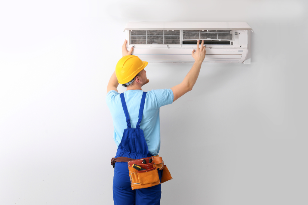HVAC worker cleaning wall mounted unit during AC maintenance in Gold Coast for residential air conditioning systems