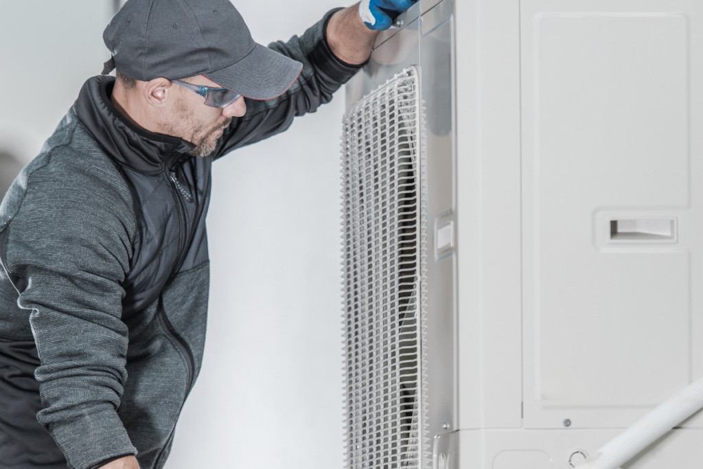 Air conditioning specialist servicing an outdoor unit during a ducted air conditioning installation Gold Coast, providing an efficient solution to replace old air conditioner equipment in residential properties.
