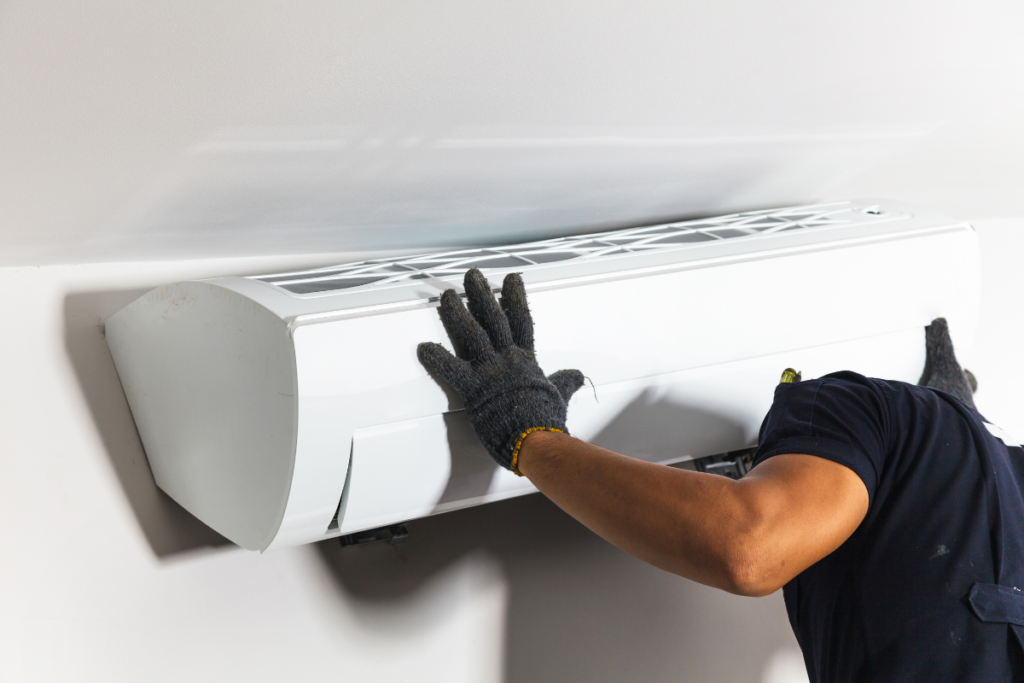 A technician carefully mounting a wall unit as part of a commercial air conditioning installation on the Gold Coast, ideal for an EOFY equipment upgrade.