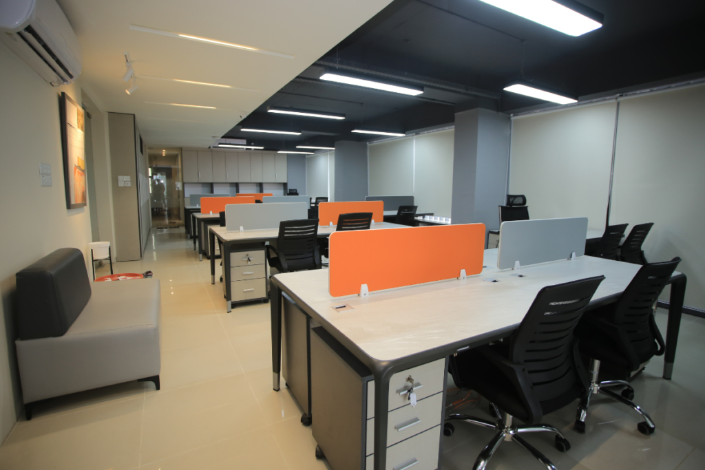 An open-plan modern workspace featuring rows of white desks with orange and grey privacy dividers, highlighting a recent commercial air conditioning installation gold coast upgrade.