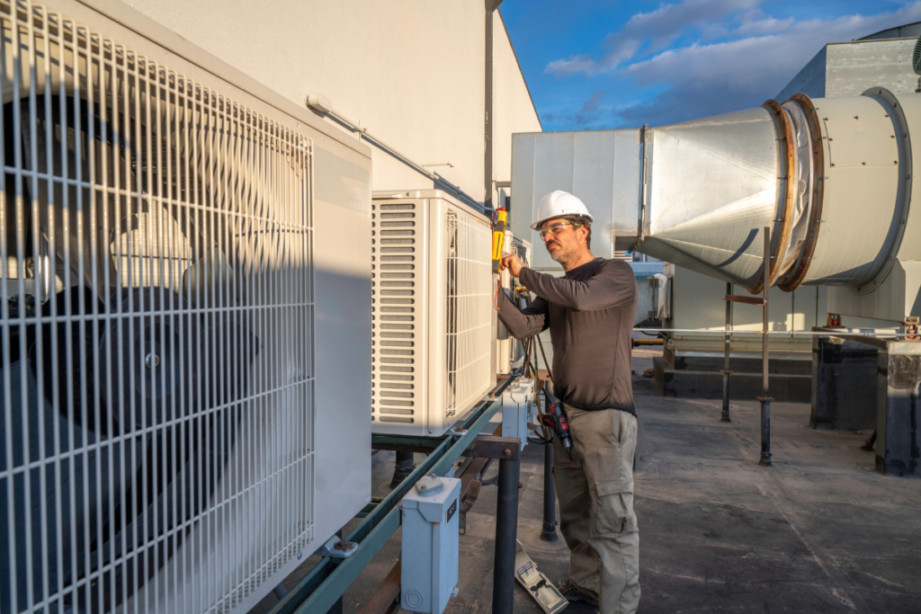 HVAC engineer conducting preventative vs reactive hotel HVAC maintenance inspection on a rooftop VRV system, helping prevent unexpected air conditioning failures in commercial hospitality properties.