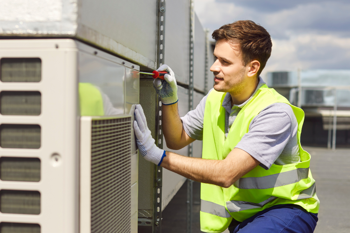Engineer servicing a rooftop VRV air conditioning system during preventative hotel HVAC maintenance, helping hotels avoid reactive repairs and improve energy efficiency.