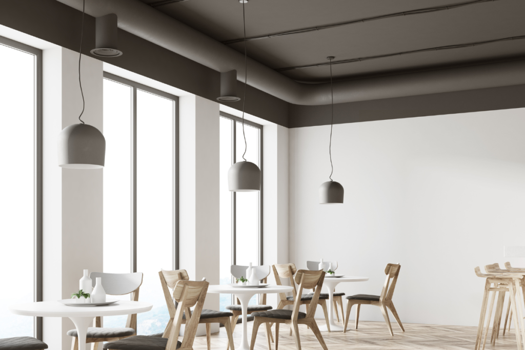 Air conditioning Gold Coast: minimalist white café dining room with ceiling vents and floor-to-ceiling windows
