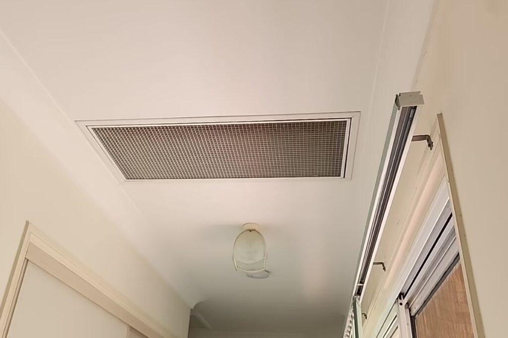 Ducted air conditioning installation Gold Coast: ceiling return-air grille in a Southport home hallway