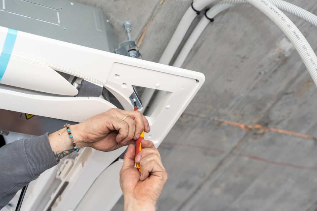 Image 6 (screwdriver on electrical terminal connection)
Technician connecting electrical wiring on an air conditioning unit as part of a professional installation