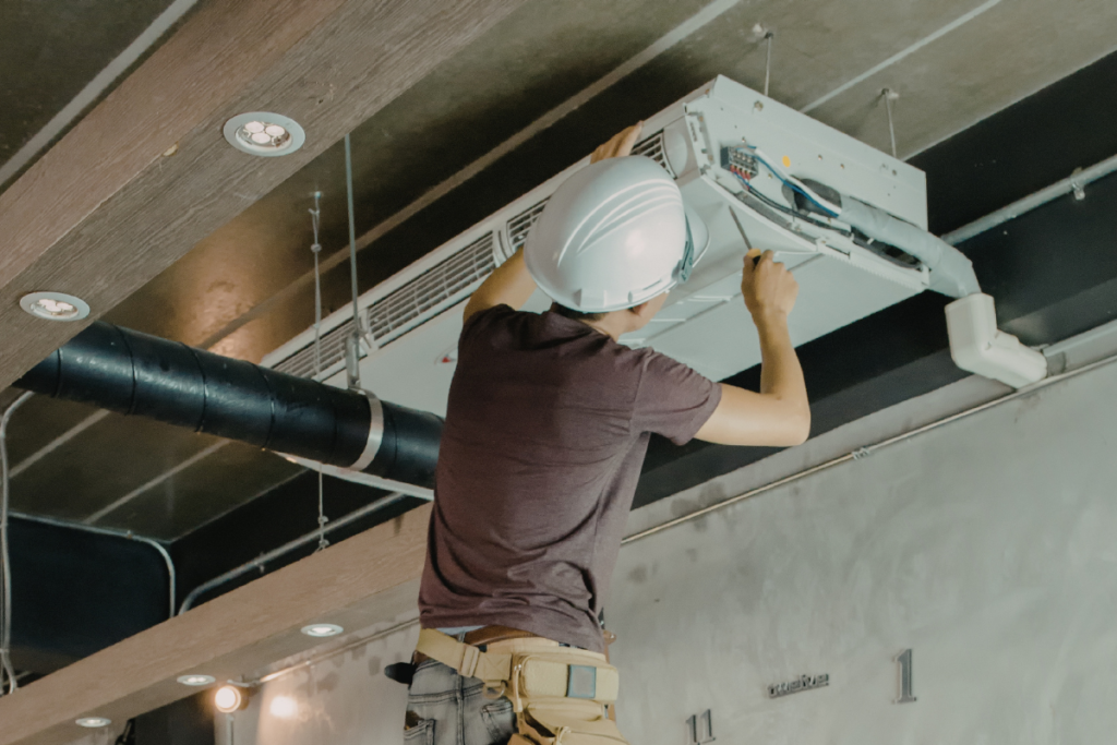 Air conditioning Gold Coast technician installing a ceiling unit to lock in off-peak winter air conditioning deals