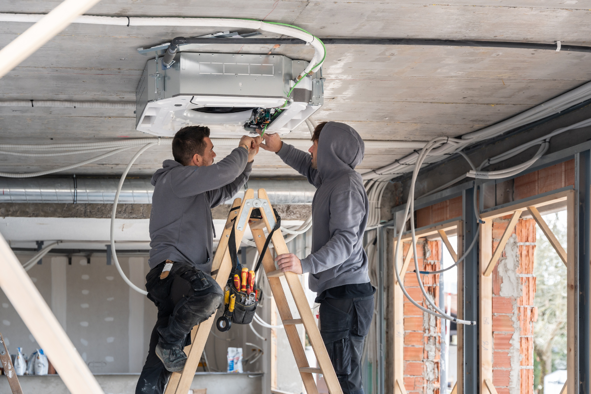 Two DEEPCHILL technicians completing a commercial air conditioning installation Gold Coast fit-out for a new business space