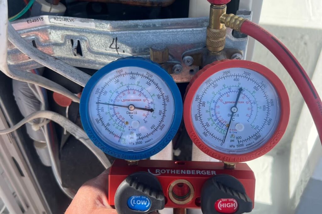 Rothenberger manifold gauges connected to an air conditioner outdoor unit to test refrigerant pressure
