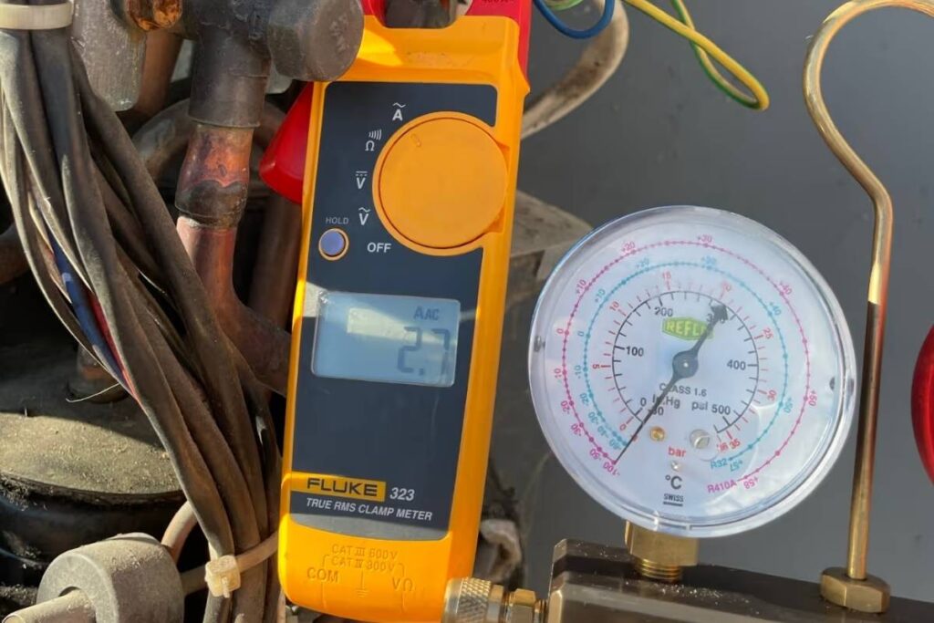 Clamp meter and refrigerant gauge used during an aircon regas Gold Coast after a nitrogen pressure and leak test