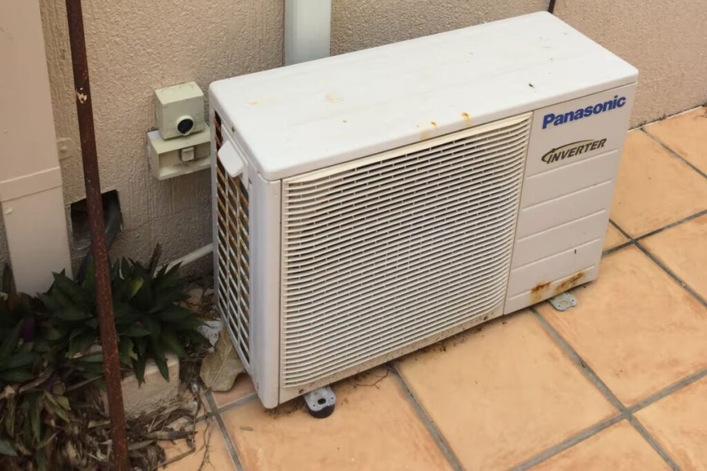 Rusty Panasonic outdoor unit prompting an air conditioner repair or replace decision on the Gold Coast