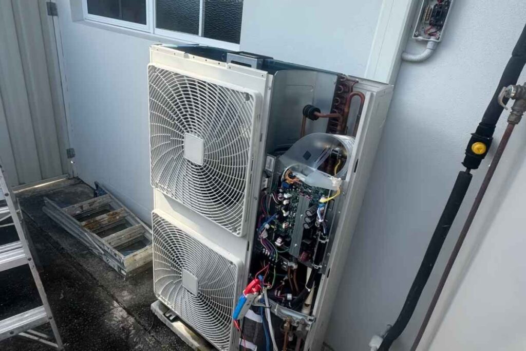 Outdoor unit opened to show the circuit board and wiring while diagnosing an air conditioner tripping circuit breaker