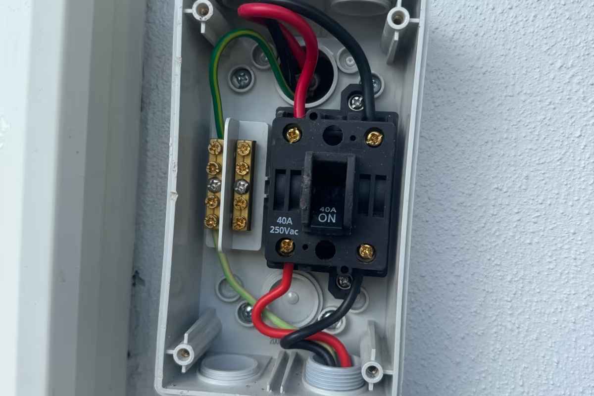 Ảnh 4 (hộp isolator mở nắp, cầu dao 40A 250Vac): Opened 40A outdoor isolator switch checked during aircon repair Gold Coast when the aircon trips the breaker when it turns on