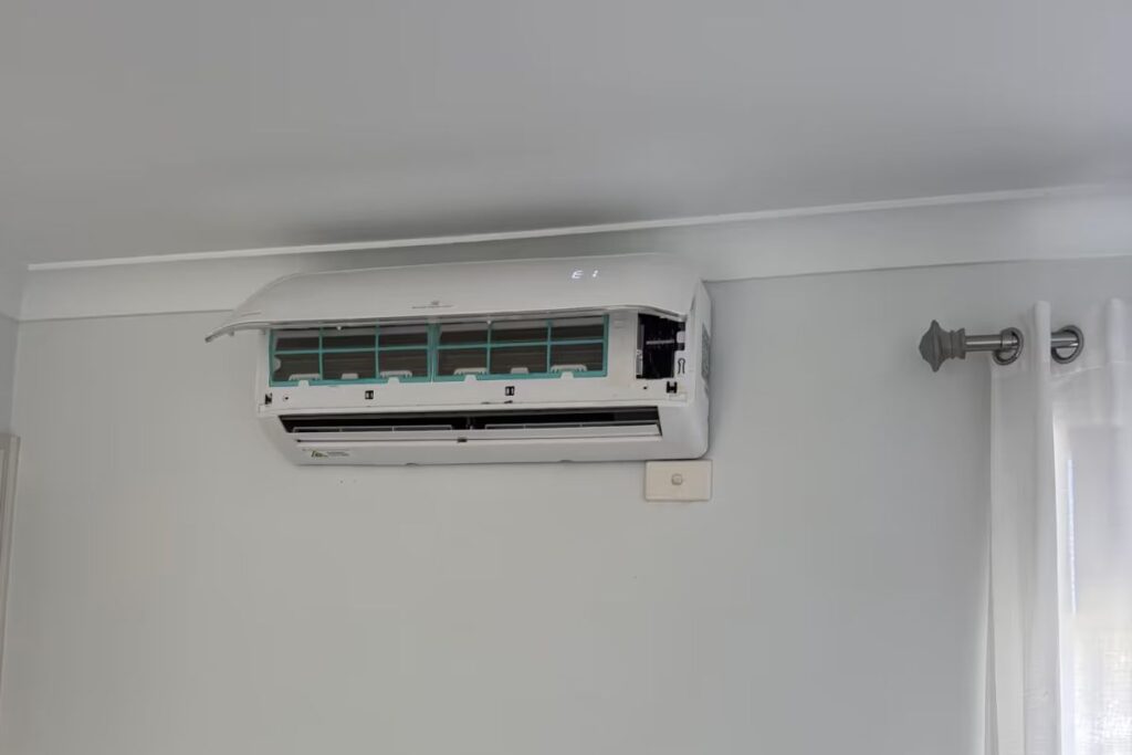 Split system air conditioner showing an "E1" error code on a Gold Coast wall — a common sign it needs repair before summer.